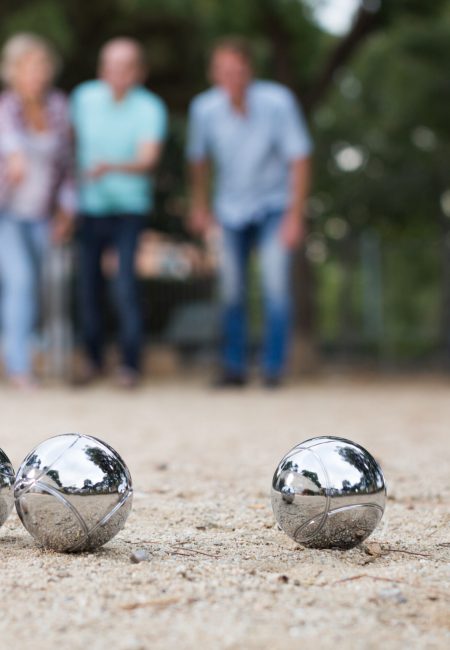Males and females playing petanque in th park on holidays